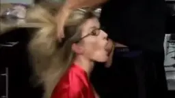 Geile Blondine im roten Satinmantel steht von hinten in einer modernen Küche und präsentiert ihren Arsch.