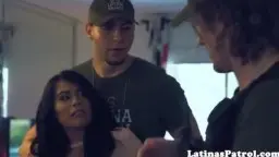 Junger Mann mit Cap steht dicht hinter seiner kleinen Schwester mit langen schwarzen Haaren und legt die Hände auf ihre Hüften.