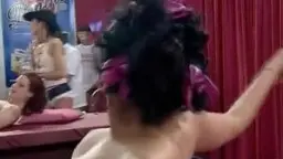 Nackte Brünette mit gespreizten Beinen auf rotem Bett, nasse Fotze und Dildo in der Hand