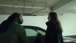 Geiler Schwarzer mit Dreadlocks steht dominant vor einer braunhaarigen Deutschen im kalten Parkhaus und fixiert sie lüstern.