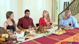 Familie sitzt am gedeckten Thanksgiving-Tisch mit Truthahn